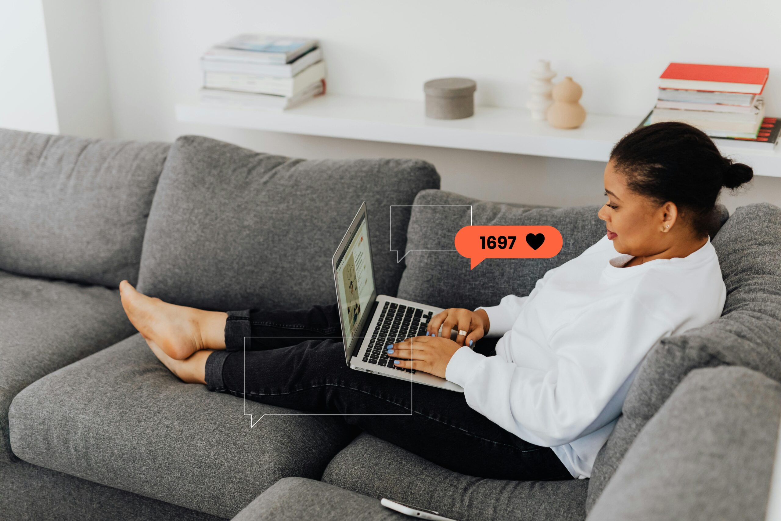 A woman enjoys working from home on her laptop, comfortably seated on a sofa.